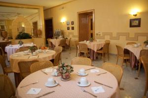 a dining room with tables and chairs with white linens at Hotel Nuovo Rebecchino in Naples