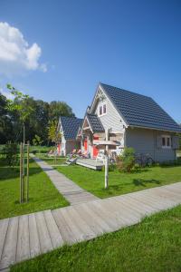 a house with a bench in front of a house at fajnemorze - Domy Szwedzkie in Dębina-Ustka
