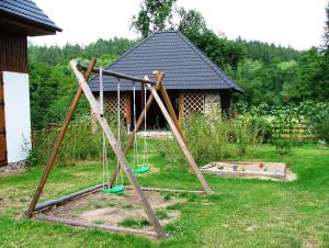 a swing set in a yard with a house at Hotel Castle Mlýn Maděrovka in Sepekov
