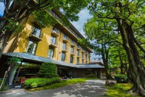 eine Aussicht auf ein gelbes Gebäude mit Bäumen in der Unterkunft Diamond Kyoto Society in Kyoto