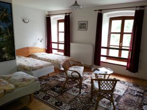 a living room with two beds and a table and chairs at Hotel Castle Mlýn Maděrovka in Sepekov