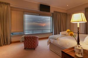 um quarto de hotel com uma cama e uma grande janela em Soul Searchers em Jeffreys Bay
