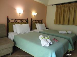 2 łóżka w pokoju hotelowym z ręcznikami w obiekcie Lirio Guest House w mieście Makrakómi