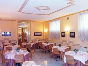 um restaurante com mesas e cadeiras com toalha de mesa branca em Hotel Nuovo Rebecchino em Nápoles