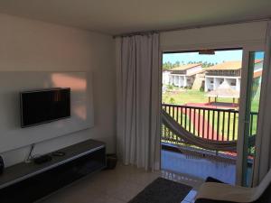 a living room with a sliding glass door to a balcony at Lindo Flat Carneiros in Tamandaré