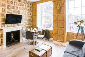 ein Wohnzimmer mit einem Tisch und einem Kamin in der Unterkunft West Bow - Magical Harry Potter-Inspired Flat near Edinburgh Castle in Edinburgh