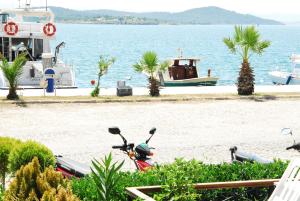 un grupo de motocicletas estacionadas en una playa con un barco en Aliye Hanim Hotel, en Ayvalık