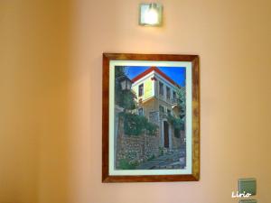 a painting of a building hanging on a wall at Lirio Guest House in Makrakómi