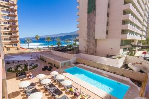 an overhead view of a pool at a hotel with a beach at Checkin Concordia Playa in Puerto de la Cruz