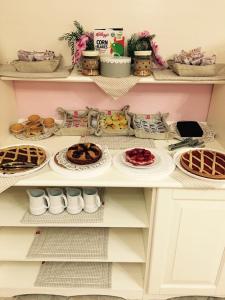 une étagère avec des assiettes de nourriture et des desserts dans l'établissement Palazzo Reginella, à Bovalino Marina