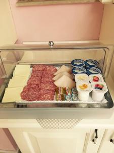 a refrigerator with meat and other food on a tray at Palazzo Reginella in Bovalino Marina