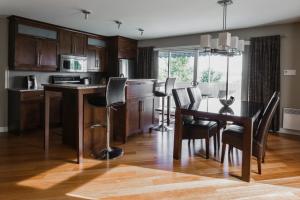 a kitchen with a table and chairs and a dining room at Hotel Le Littoral in Quebec City
