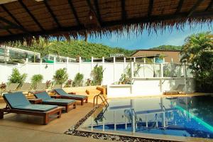 una piscina con tumbonas y una piscina en Karon Pool Hotel, en Karon Beach