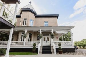 Una gran casa de ladrillo con una puerta blanca en Littoral - Hôtel & Spa en Quebec