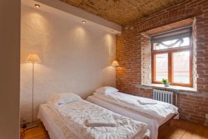 two beds in a room with a brick wall at Beguta Guest House in Haapsalu