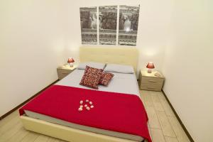 1 dormitorio con 1 cama grande con manta roja en Case Vacanza Via Mozart, en Porto Cesareo