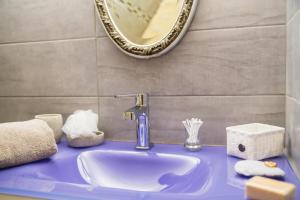 ein Badezimmer mit einem blauen Waschbecken und einem Spiegel in der Unterkunft Au coeur de Beynac, une maison de caractère avec jardin terrasse in Beynac-et-Cazenac