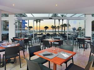 a restaurant with tables and chairs and a view of the ocean at Apto a pie de playa con vistas increíbles! in Torremolinos