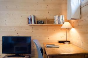 a wooden desk with a monitor and a lamp on it at Django in Les Gets