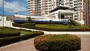 un edificio con un jardín con arbustos y flores en Reserva del Peñon, en Girardot