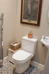 a bathroom with a white toilet and a sink at Neidpath Castle Cottage in Peebles