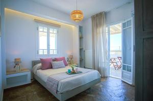 a bedroom with a bed with a table on it at JKG OIKIA in Agia Anna Naxos +64 photos