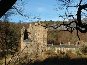 an old castle sitting on top of a hill at Neidpath Castle Cottage in Peebles