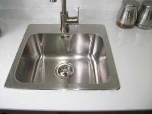 a stainless steel sink in a white counter top at Westpark Apartment in East Kilbride