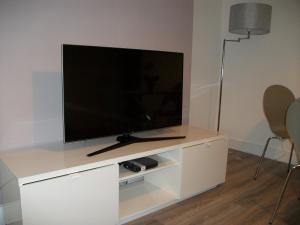 TV de pantalla plana en un centro de entretenimiento blanco en Westpark Apartment en East Kilbride