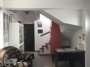 sala de estar con escalera, sofá y mesa en Hostal del Milagro en Salta