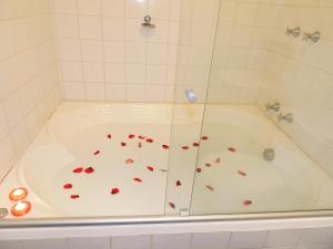 a bath tub with red hearts on the floor at Pousada Cantinho das Estrelas in Monte Verde