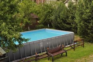 a swimming pool in a yard with a bench at Kovalska Sadyba in Slavske