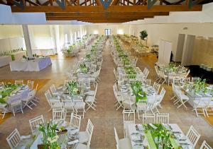 a large room with white tables and white chairs at INATEL Caparica in Costa da Caparica