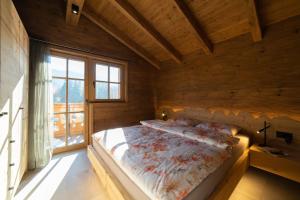 ein Schlafzimmer mit einem Bett in einem Holzzimmer in der Unterkunft Chalet Hinterrugg in Wildhaus