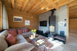 a living room with a couch and a tv at Chalet Hinterrugg in Wildhaus
