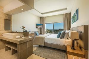 a bedroom with a bed and a tub and a sink at Caneiros Luxury House & Suites in Ferragudo +30 photos