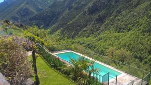 a swimming pool with a fence next to a mountain at Bergerie " Le Cortal " in Nohèdes
