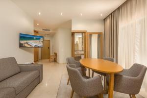 a living room with a couch and a table and chairs at Caneiros Luxury House & Suites in Ferragudo
