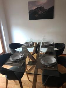 stół z czarnymi krzesłami i okularami w obiekcie Apartment Himmelreich w mieście Brunico +6 zdjęć