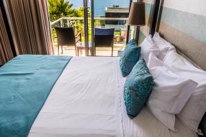 a bed with blue and white pillows on it at Atlantida Mar Hotel in Praia da Vitória