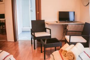 a living room with two chairs and a tv at B&B Santa Monica in Pero