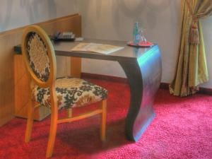 a desk with a chair and a table with a book at Klostergasthof Raitenhaslach in Burghausen