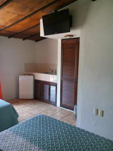 a room with a bed and a kitchen with a tv at Hotel Uke Inn Terán in Tuxtla Gutiérrez