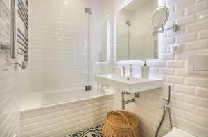 uma casa de banho com um lavatório, uma banheira e um espelho. em Marquês de Pombal Metropolitan Flat em Lisboa