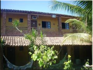 a brick house with a palm tree in front of it at Pousada Água de Côco in Prado +18 photos