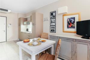 sala de estar con mesa blanca y TV en Adriano Residence, en Bolonia 63 fotos más