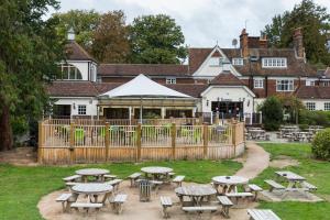 un gruppo di tavoli da picnic di fronte a un edificio di The Conningbrook Hotel ad Ashford