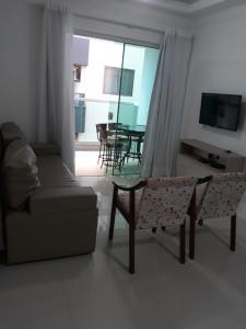 sala de estar con sofá y mesa en Lindo Apto Em Bombinhas, en Bombinhas