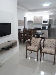 cocina y comedor con mesa y sillas en Lindo Apto Em Bombinhas, en Bombinhas
