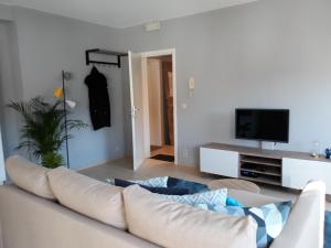 a living room with a couch and a tv at Panda Parc Appartment proche Pairi Daiza-Shape-Nato in Lens
